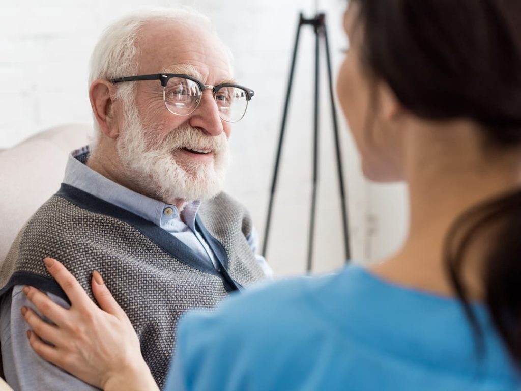 Elderly Man Receiving Help From A Nurse